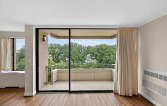 A room with a sliding glass door leading to a balcony.