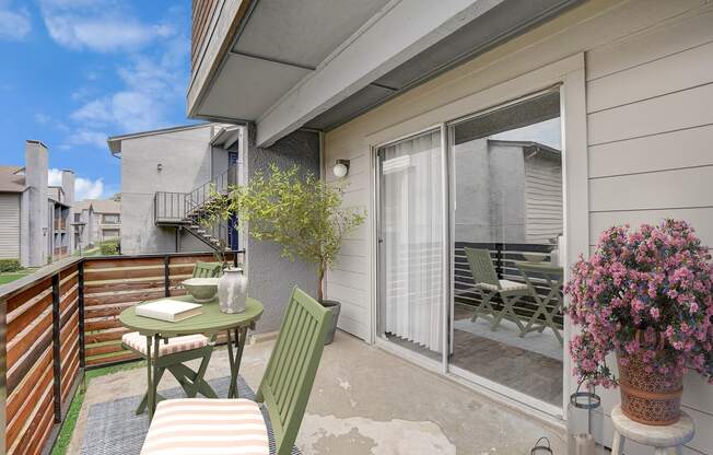 a patio with a table and chairs and a sliding glass door