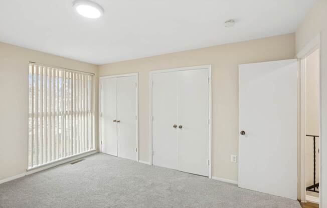 A room with white doors and a carpeted floor.