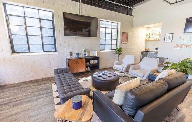 a living room with couches and chairs in front of a flat screen tv
