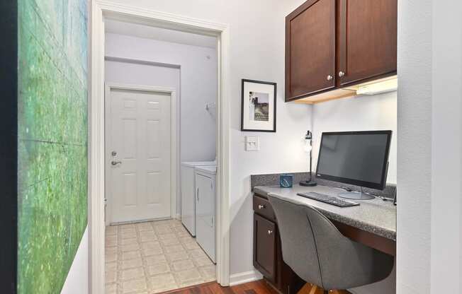 a office with a computer desk and a door to a bathroom at Sovereign at Overland Park, Overland Park, KS  