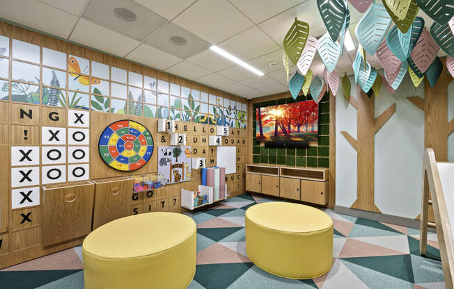 a mural of a tree and alphabet blocks decorates the wall of a classroom