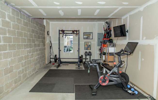 A room with a brick wall and a treadmill.