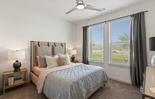 A bedroom with a large bed and a ceiling fan.