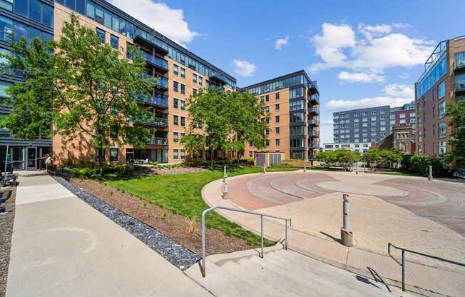 A playground with a slide and a climbing frame in the foreground with apartment buildings in the background.