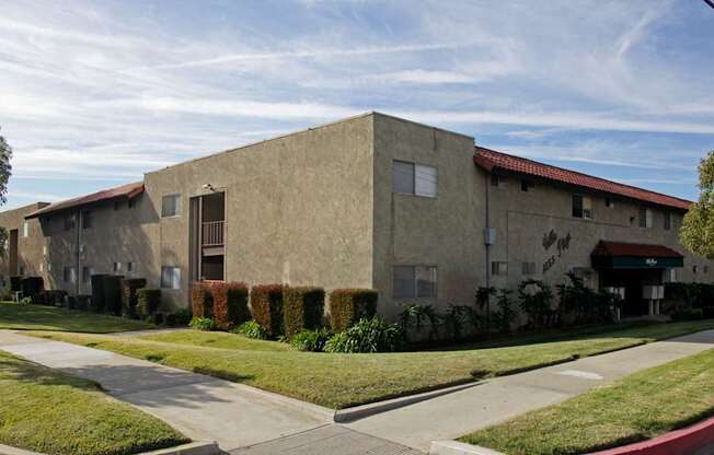 A building with a red roof and a green lawn in front.