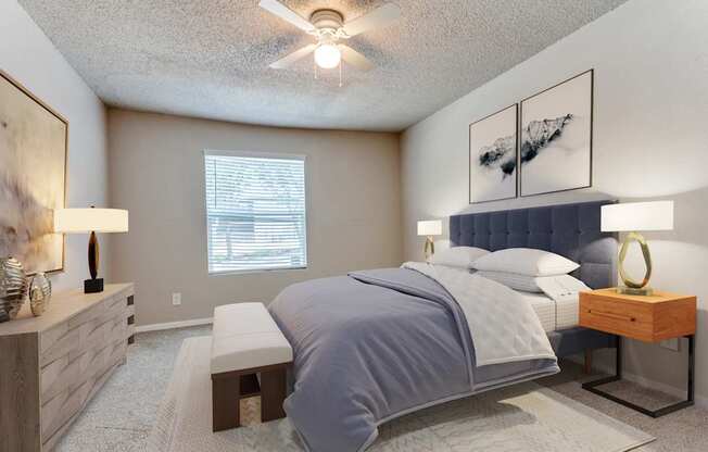 A bedroom with a large bed and a ceiling fan.