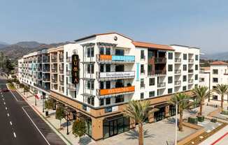 A multi-story building with a white facade and a red roof.