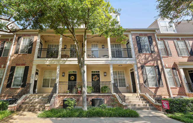 A row of townhouses with a tree in front.