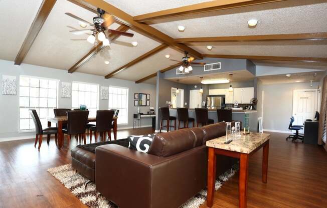 a large community room with a leather couch and a table