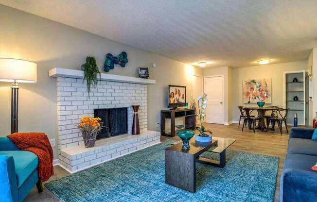 A living room with a fireplace and a blue couch.