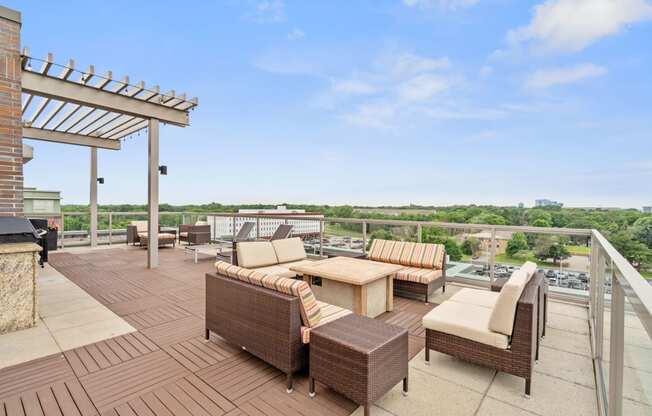 a rooftop terrace with wicker furniture and a view of the city