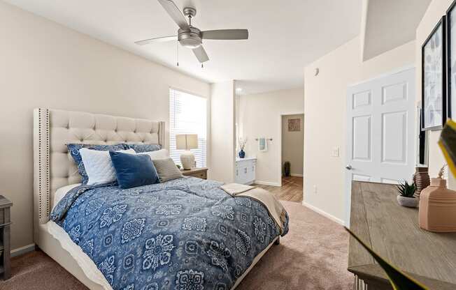 A bedroom with a large bed and a ceiling fan.