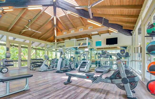A gym with a variety of equipment including treadmills, weights and exercise machines.