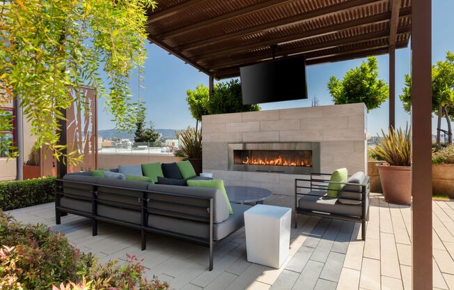 a patio with a fireplace and lounge chairs