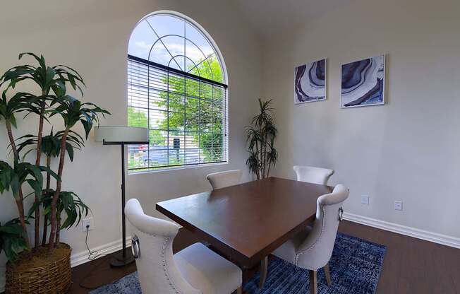 A dining room with a wooden table and chairs.