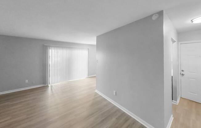 an empty living room with white walls and wood flooring