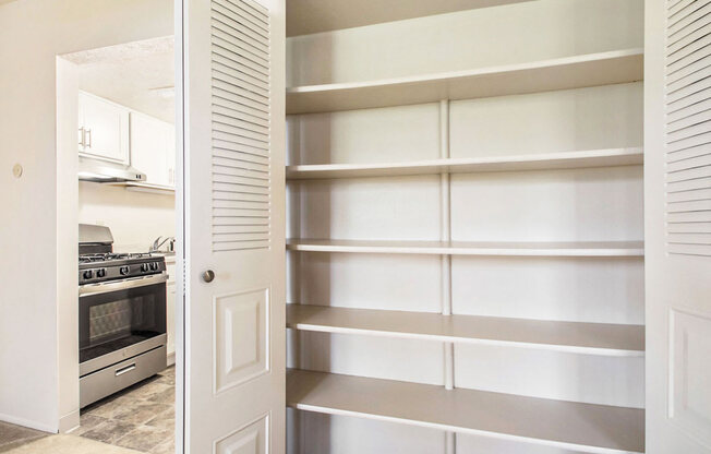 a kitchen with a white door and white shelves