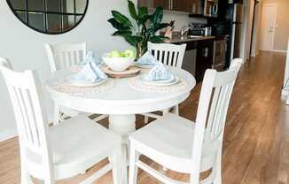 A white dining table with four chairs and a bowl of fruit on it. at The Platform, Washington, 98032