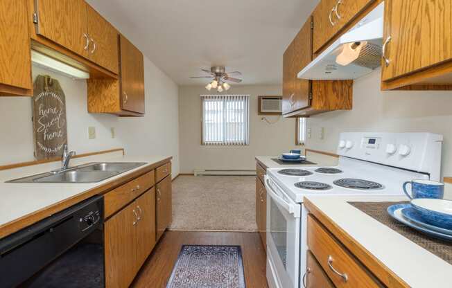 the view of a kitchen with a stove top oven and a sink. Fargo, ND Park Circle Apartments.