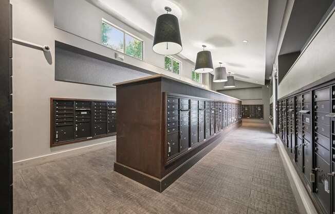 A long hallway with a row of lockers on the right and a wooden cabinet in the middle.