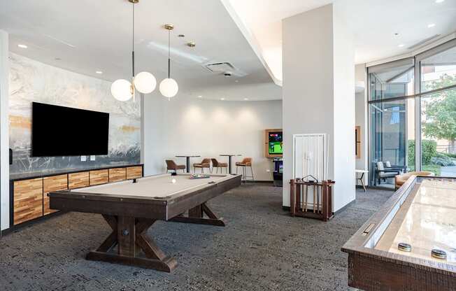 A room with a pool table and a tv.