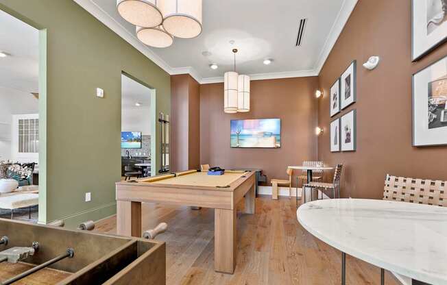 A room with a pool table and a tv.