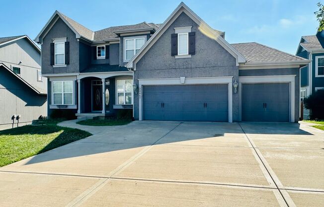 {20067} Custom Built Home in Woodland Manor + Open Main Level with Modern Lighting and Hardwood Flooring + Finished Walk Out Basement + Enclosed Sunroom + Three Car Garage + Fenced Yard