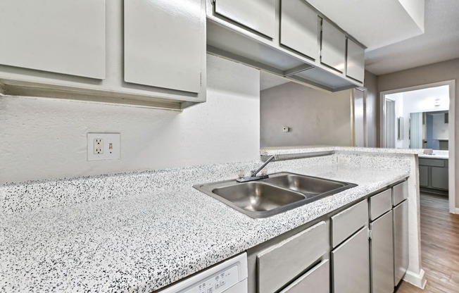 A kitchen with a granite countertop and stainless steel appliances.