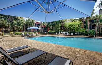 a swimming pool with tables and umbrellas