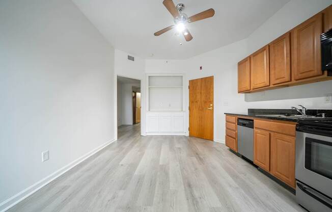 A kitchen with wooden cabinets and a ceiling fan.