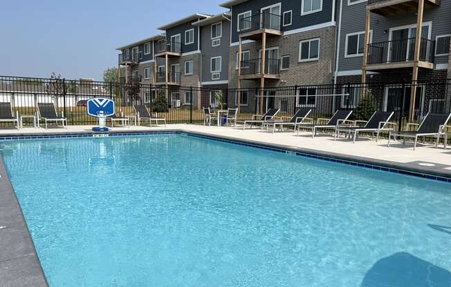 Sparkling blue pool surrounded by lounge chairs.