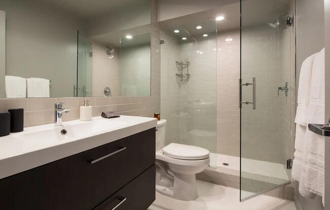 A white toilet sits next to a sink in a modern bathroom.