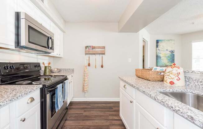 A kitchen with a black stove top oven and white cabinets.