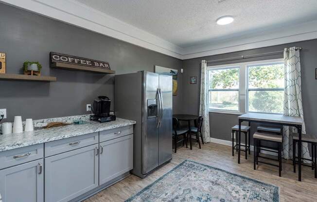 a kitchen with a refrigerator and a table with chairs