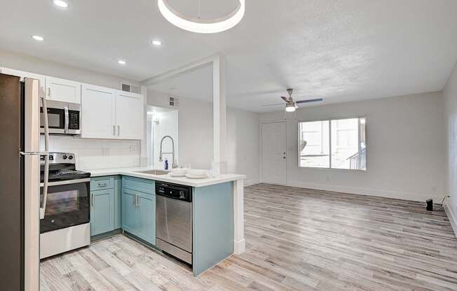 A kitchen with a refrigerator, oven, and sink.