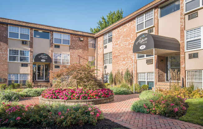 A brick building with a flower bed in front.