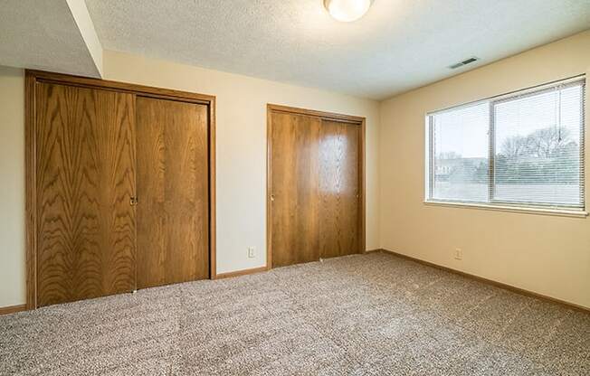 Bedroom with two closets providing plenty of storage space at Fountain Glen Apartments