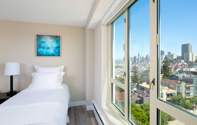 a bedroom with a bed and a large window with a view of the city