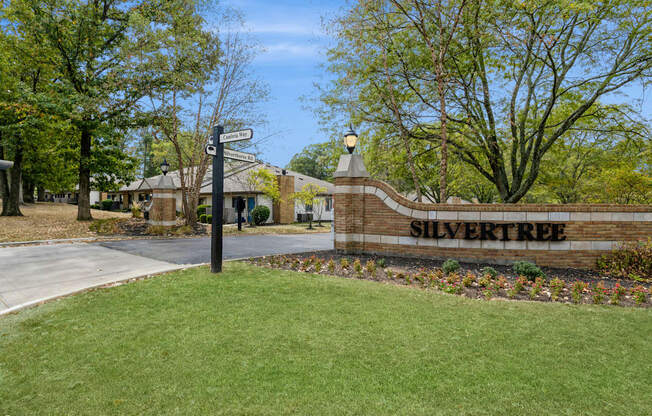 a street sign in front of a brick building with trees