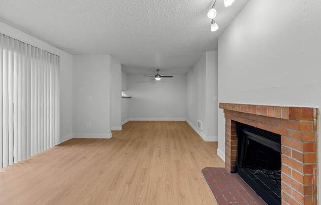 A room with a fireplace and wooden flooring.