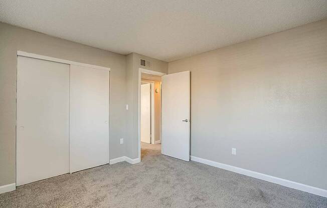 A room with a carpeted floor and two doors at Sterling Point Apartment Homes, Arizona