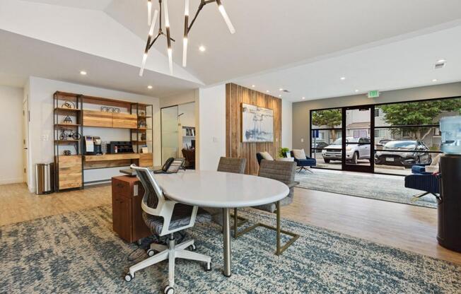 A conference room with a white table and chairs, a bookshelf, and a view of the street outside.
