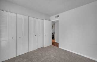 an empty room with white closets on the wall