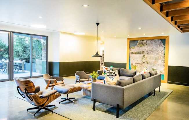 A living room with a grey couch and a wooden chair.