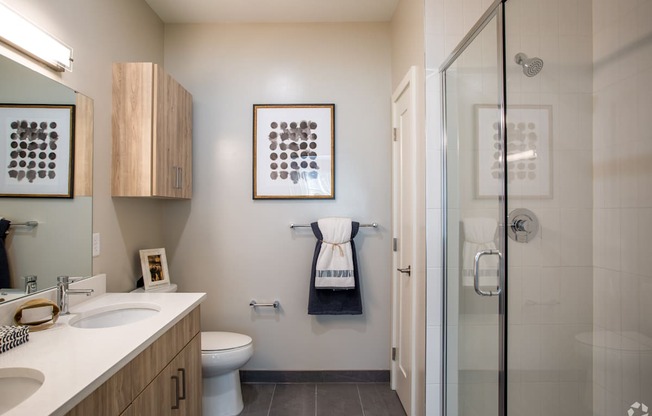A bathroom with a toilet, sink, and shower.