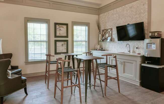 A kitchen with a table and chairs in front of a window.
