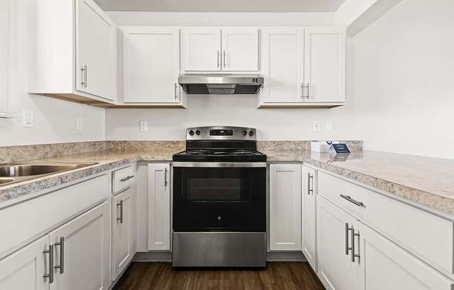 A modern kitchen with white, shaker-style cabinets and a stainless steel oven at Tanglewood Apartments, Oak Creek, WI
