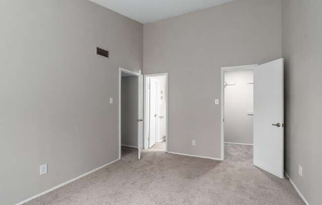 a bedroom with a carpeted floor and a door to a closet