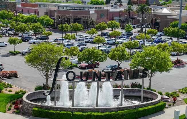 A fountain in the center of a parking lot with the word "Ontarians" written on it.